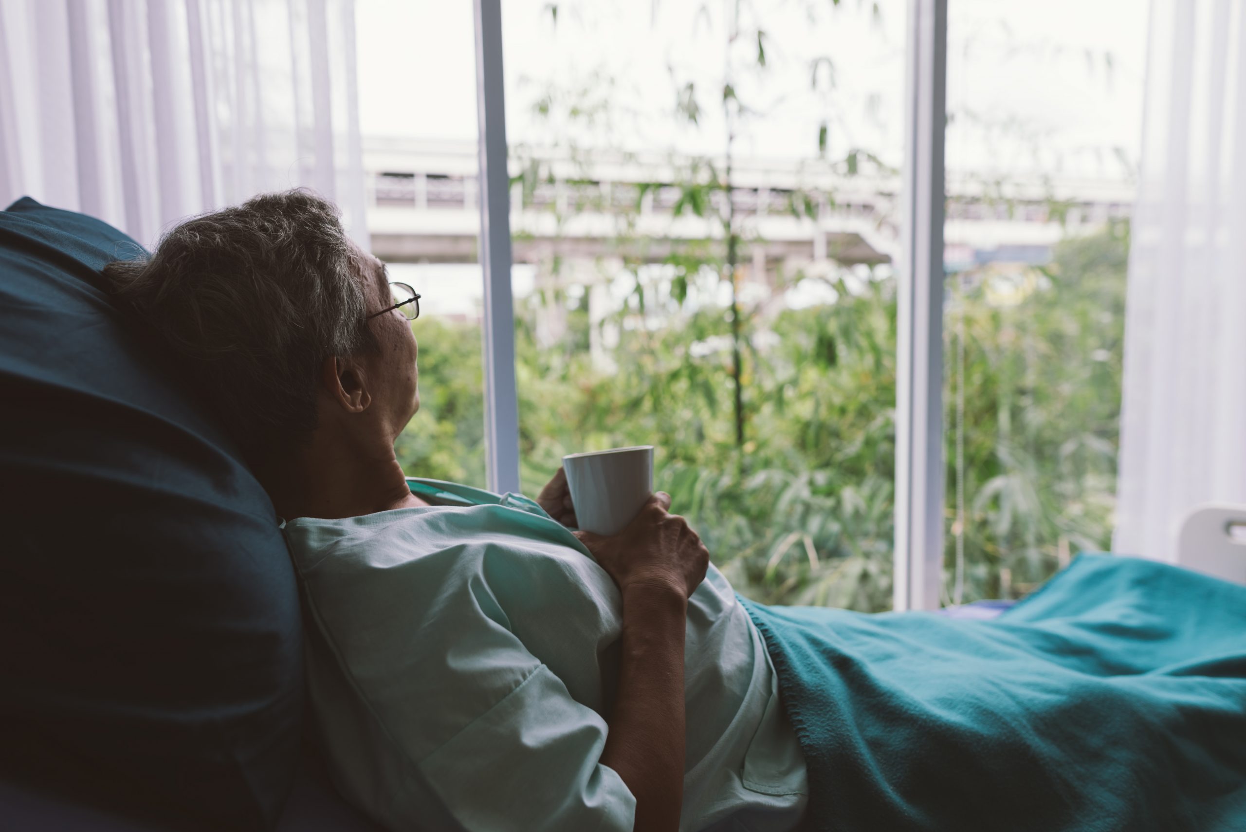 Senior man on a hospital bed alone in a room