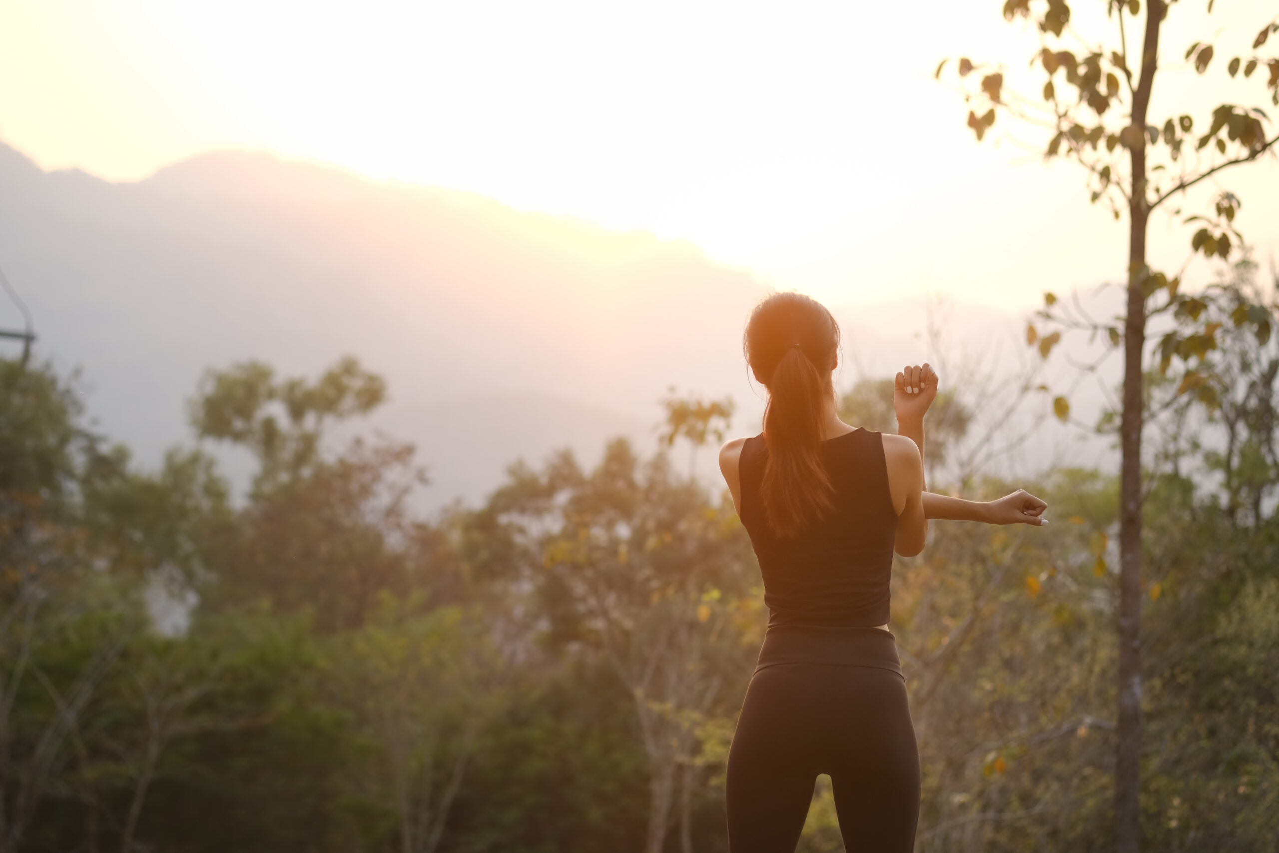 Rear,View,Healthy,Young,Woman,Stretching,In,The,Park,Before