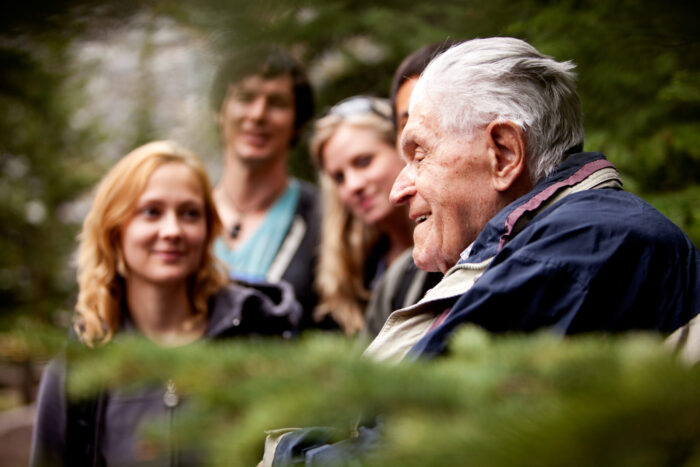 An,Elderly,Man,Telling,Stories,To,A,Group,Of,Young
